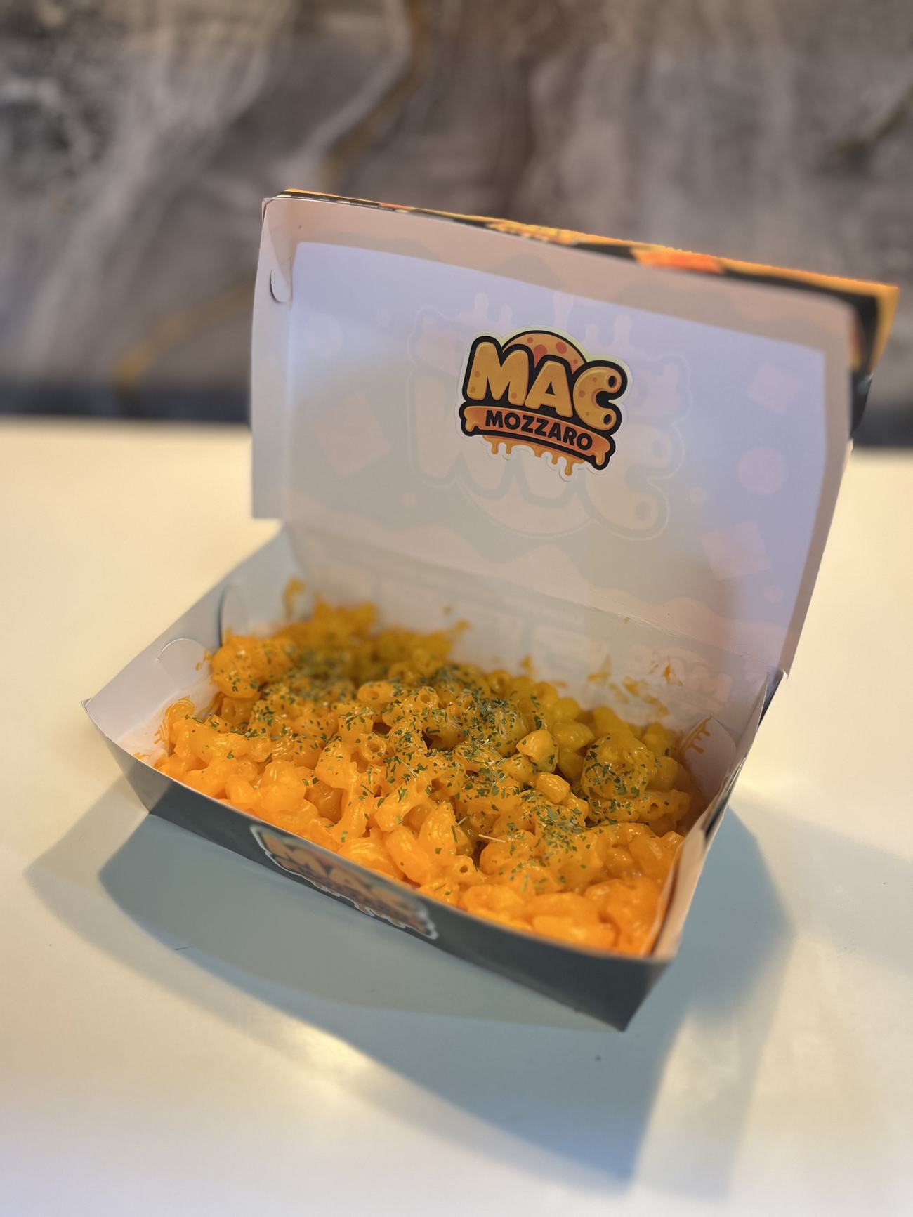 Mac and cheese Mac Mozzaro dalam kemasan, ditaburi bumbu kering